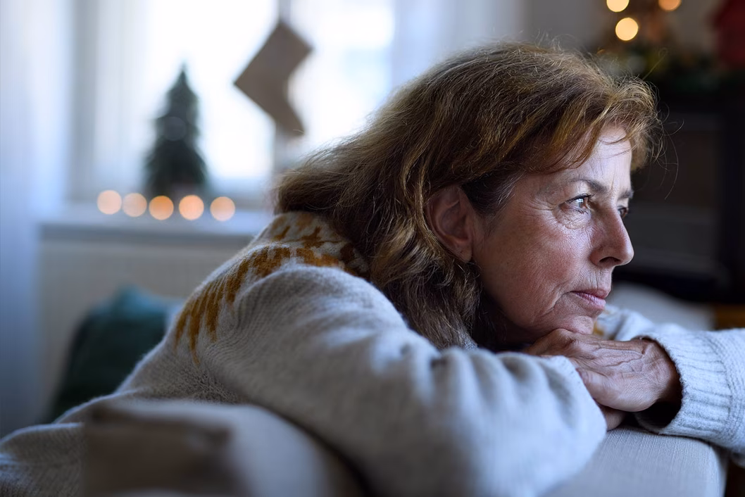 Photo of a woman leaning over the back of a sofa