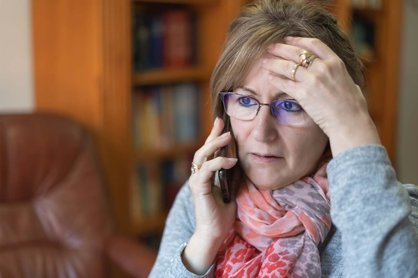 Photo of a woman with gold rings using a mobile phone