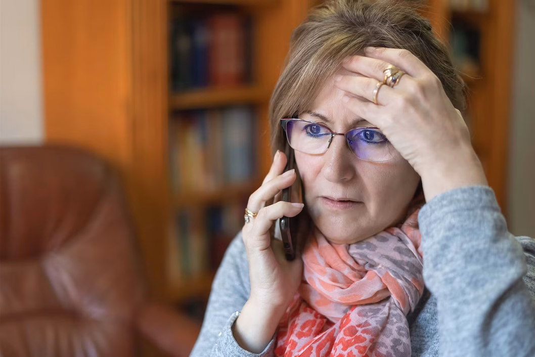 Photo of a woman with gold rings using a mobile phone