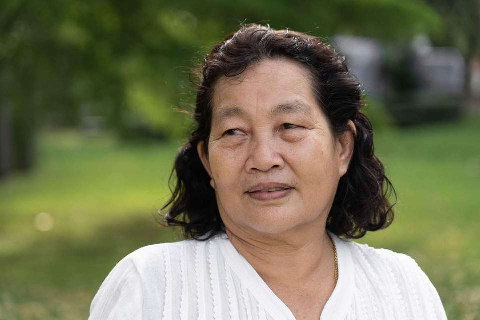 Older woman wearing a white shirt in a green park