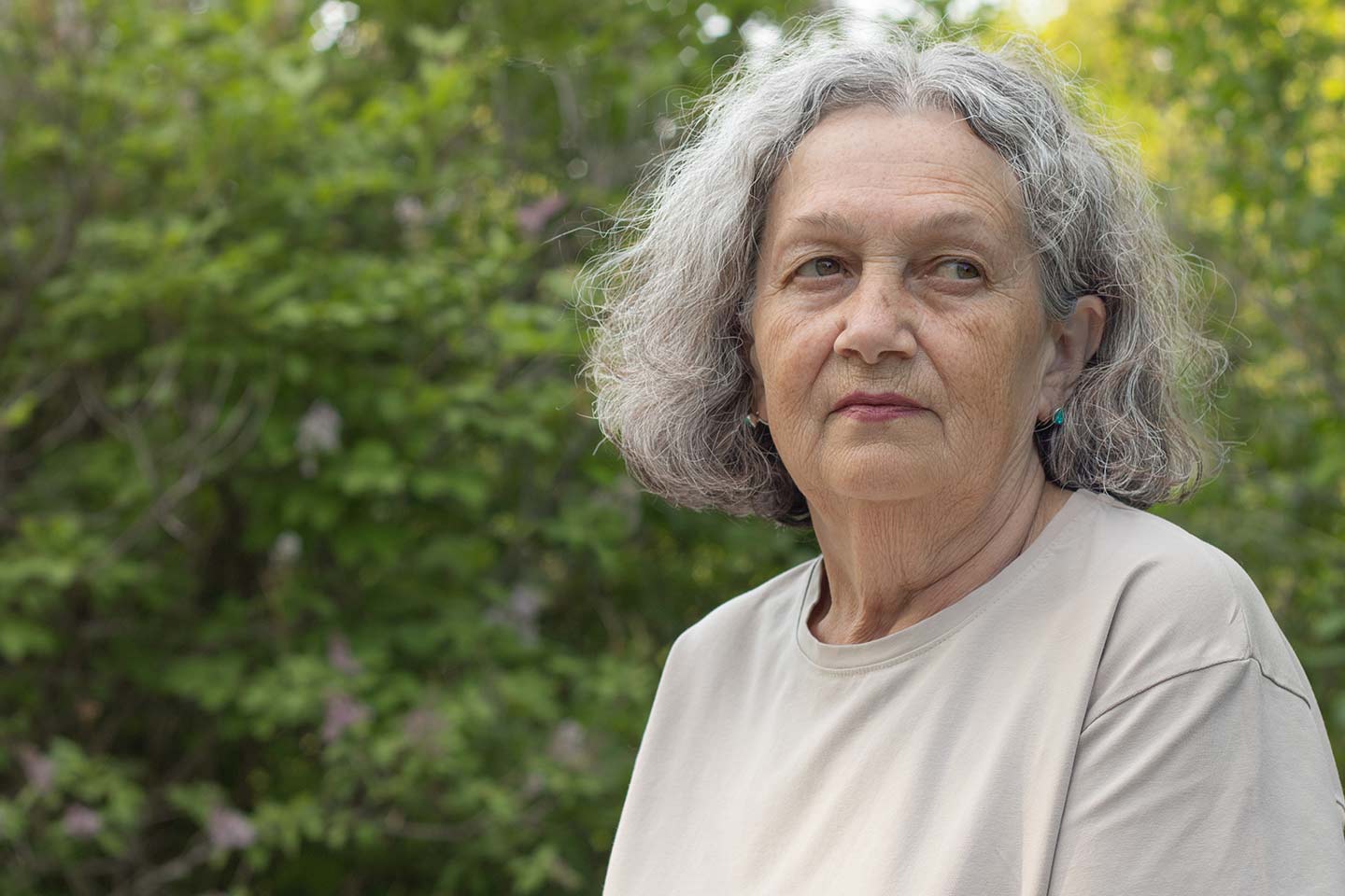 Photo of a woman wearing a beige t shirt in a park