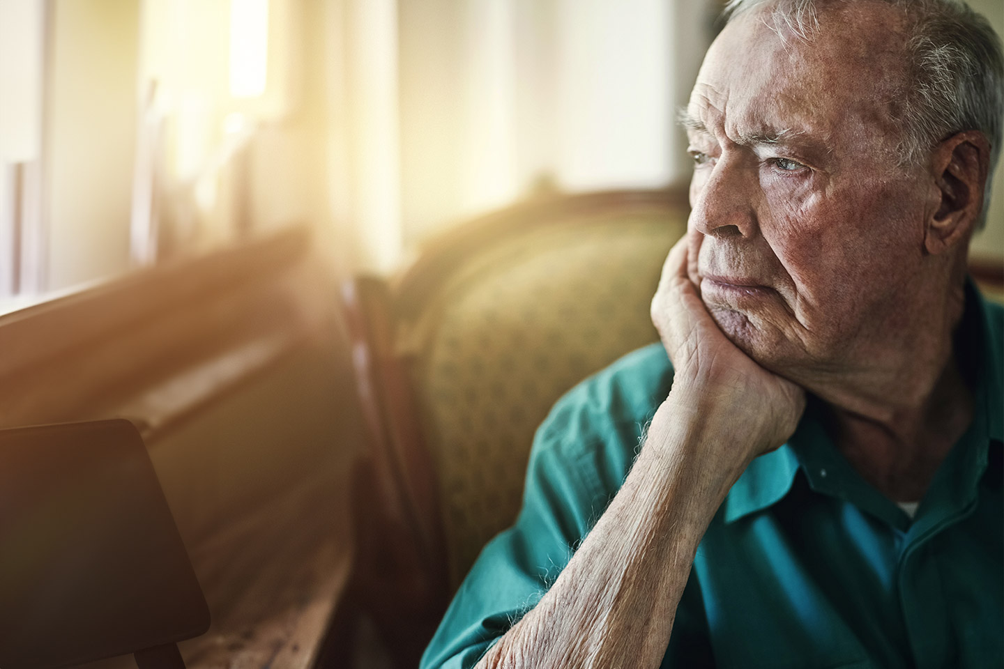 Photo of man in green shirt with chin in hand