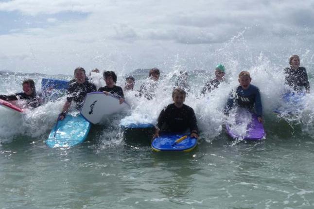 A photo of a group of women surfing and bodyboarding