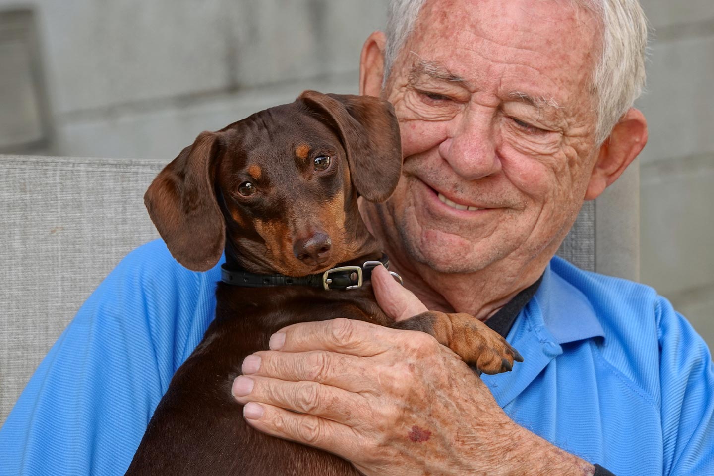 Photo of older man cuddling his adorable dachshund