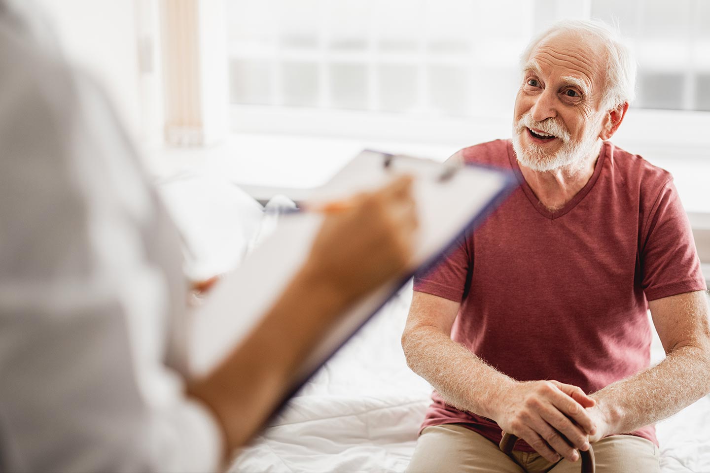 Photo of a patient in a red t-shirt talking to a health worker