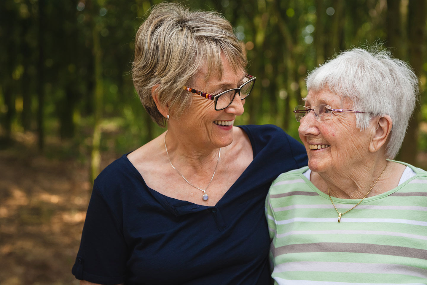 Photo of two women embracing and smiling at each other