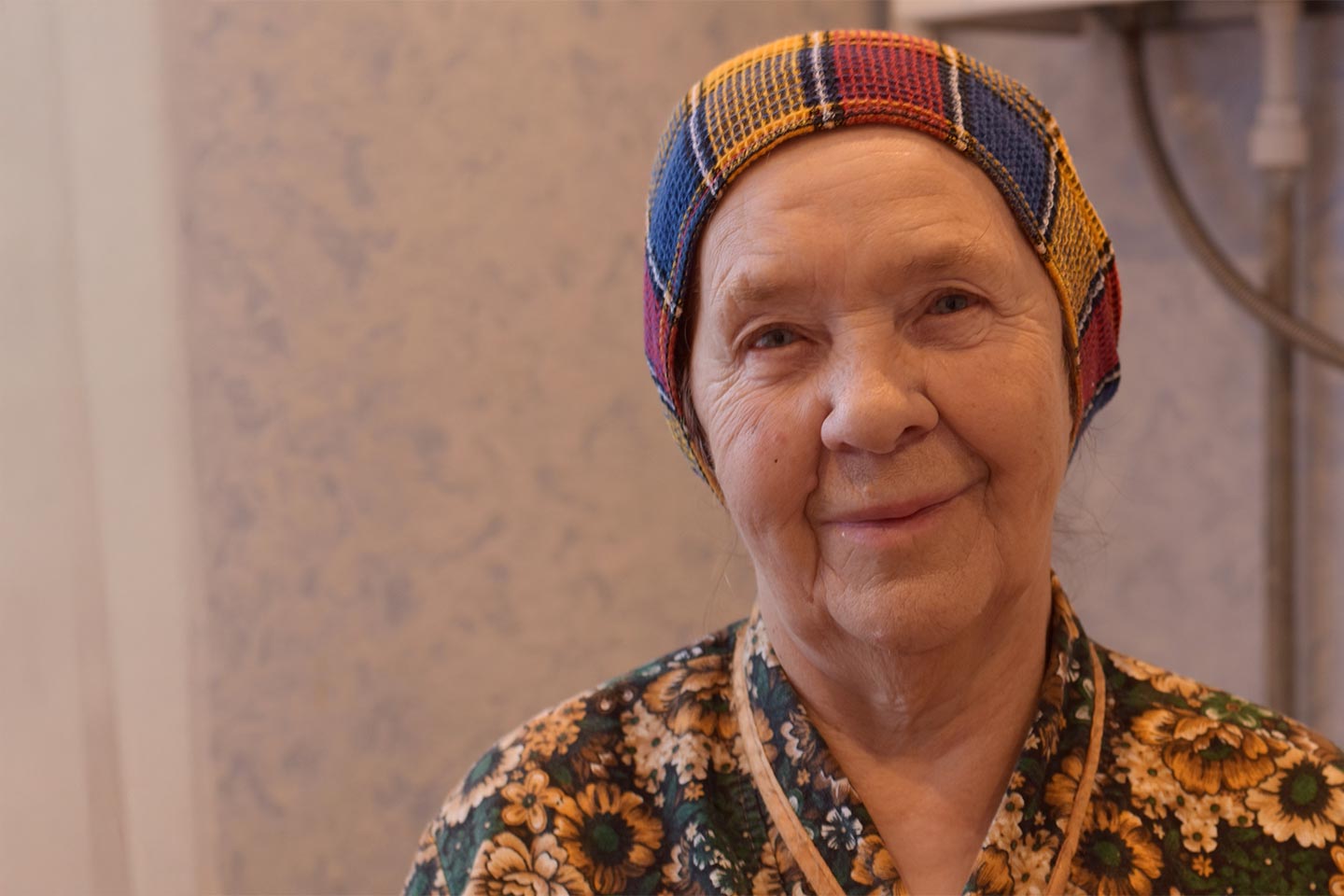Photo of a woman in floral pyjamas and a knit cap