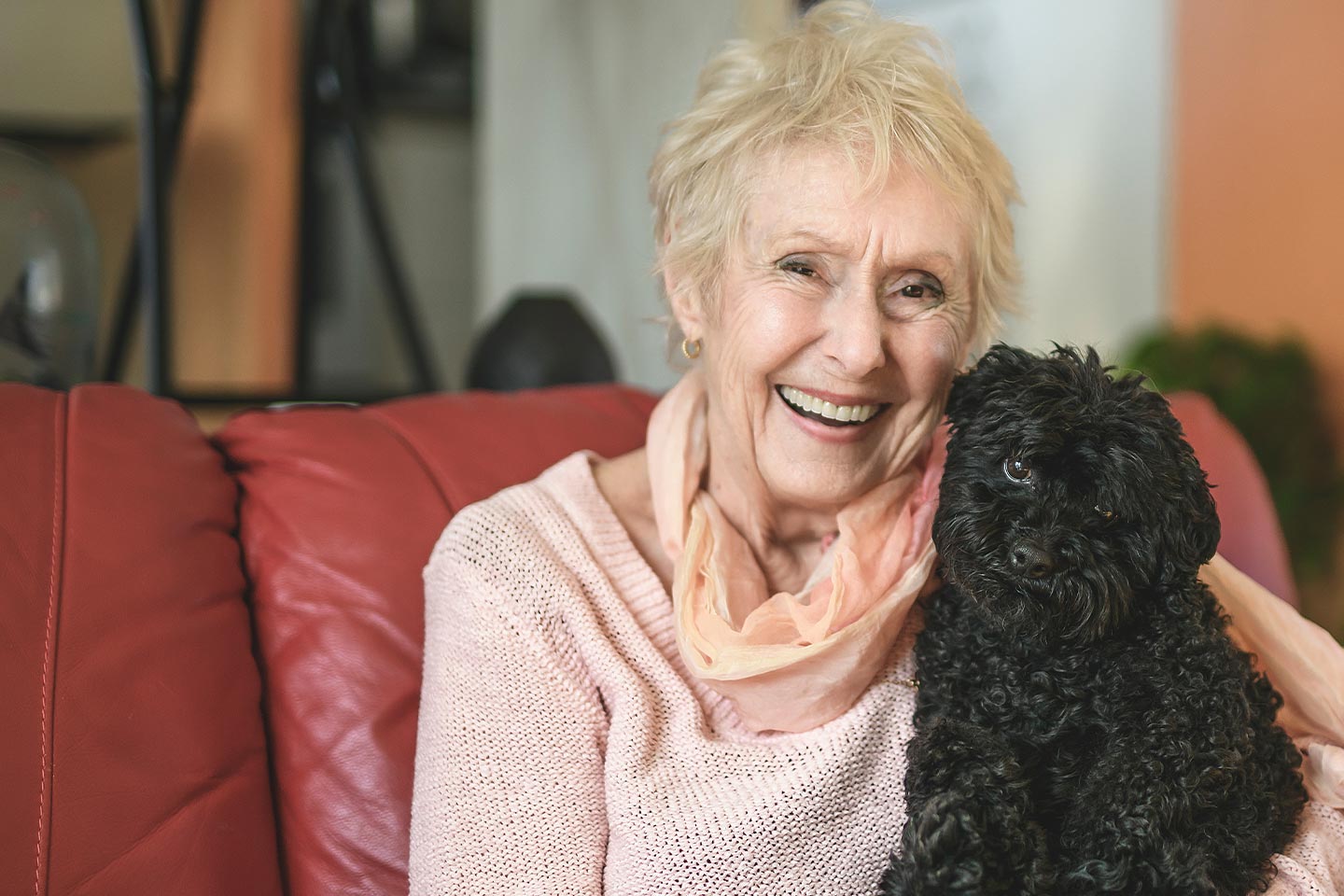 Photo of a woman in apricot with an adorable black puppy
