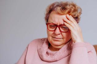 Photo of woman wearing red glasses and pink jumper