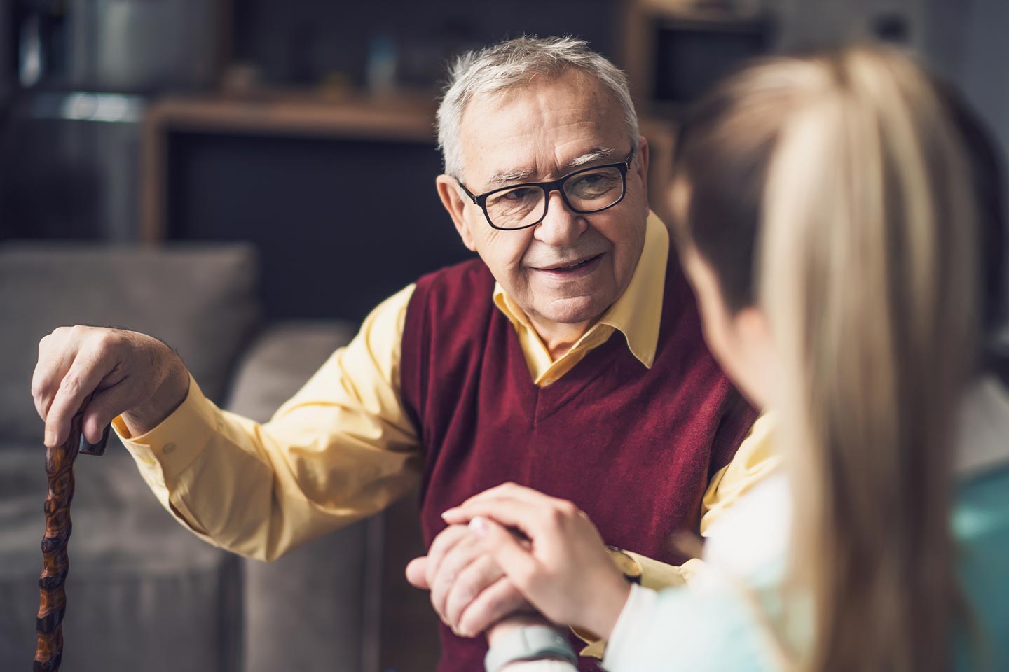 Photo of a man with a maroon vest and a yellow shirt
