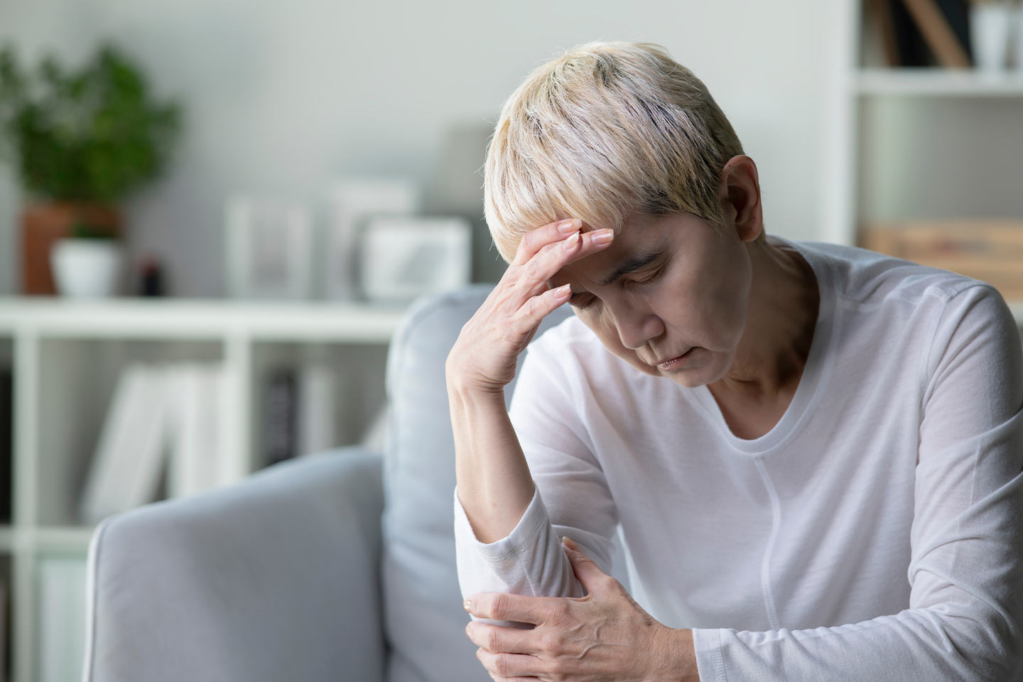 Photo of a woman with blonde pixie cut and white top