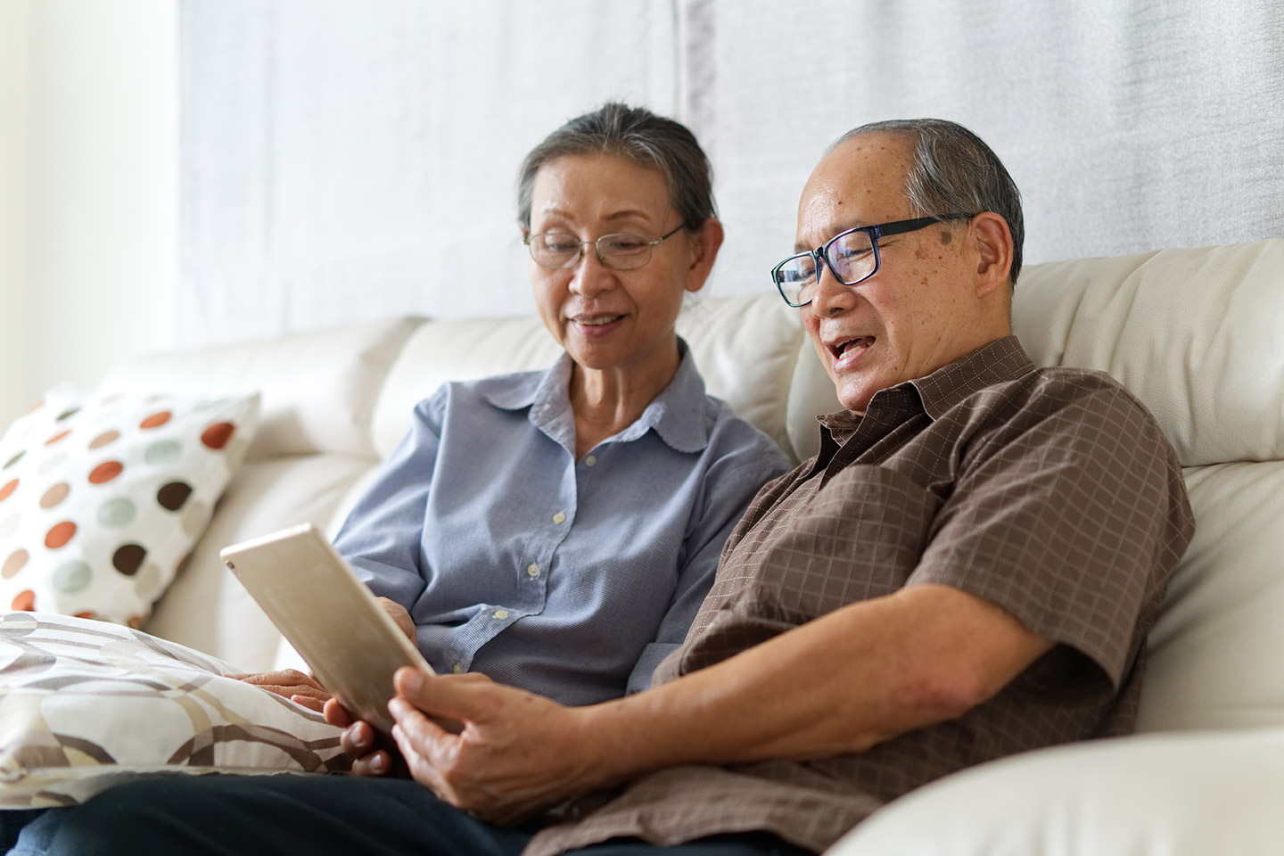 Image of two older Asian Australians reading on a tablet