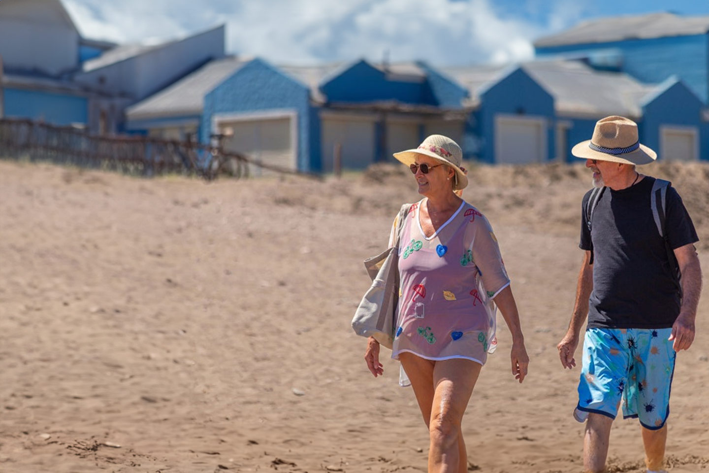 Photo of couple walking along a sunny beach