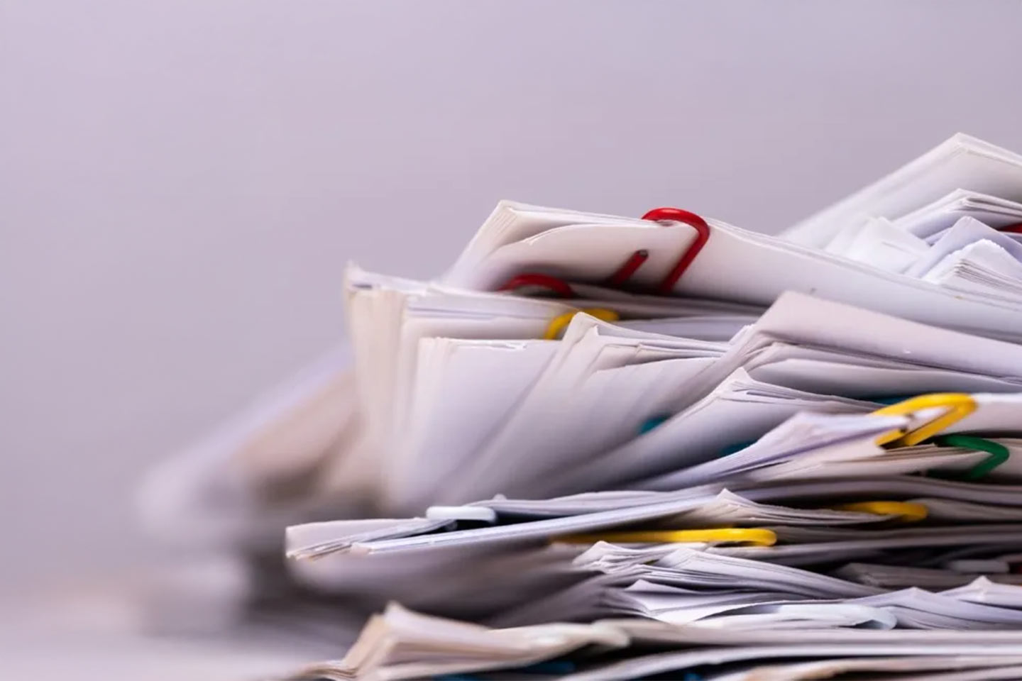 Photo of a messy stack of papers and paper clips in closeup