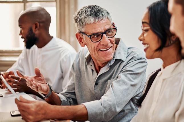Photo of diverse work colleagues chatting in a meeting