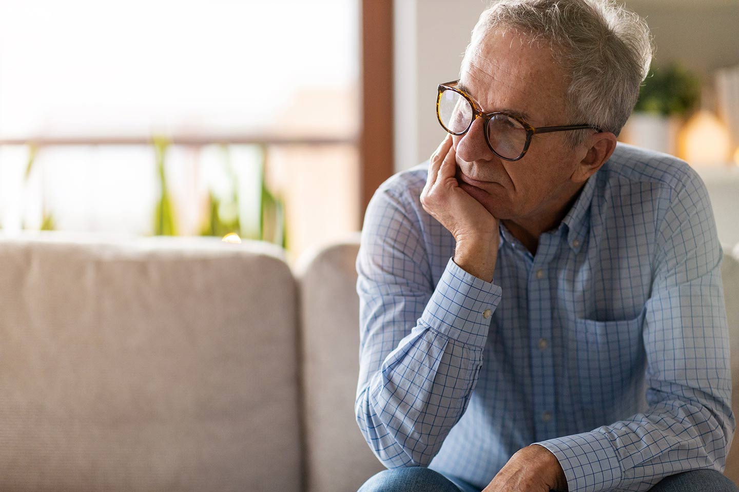 Photo of grey haired man with chin in hand