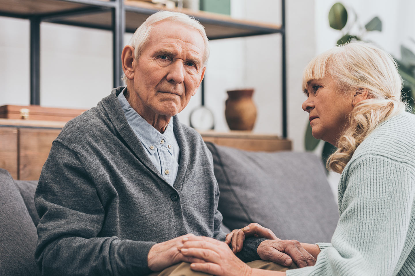 Photo of concerned couple clasping hands