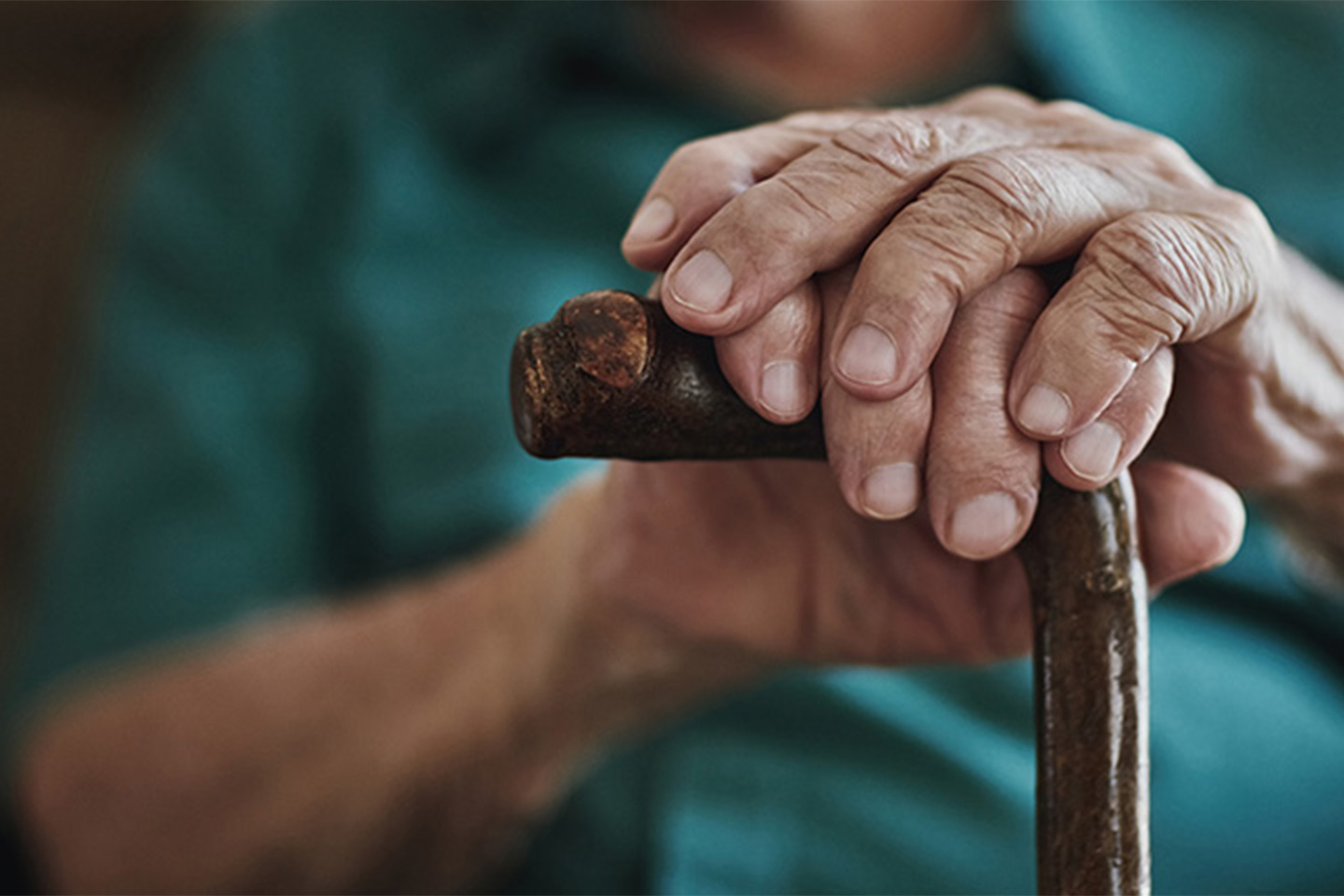 Photo of senior hands on a walking stick