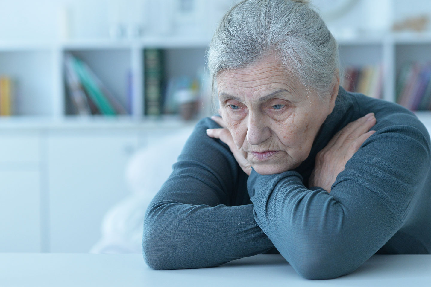 Photo of a dejected woman wearing grey