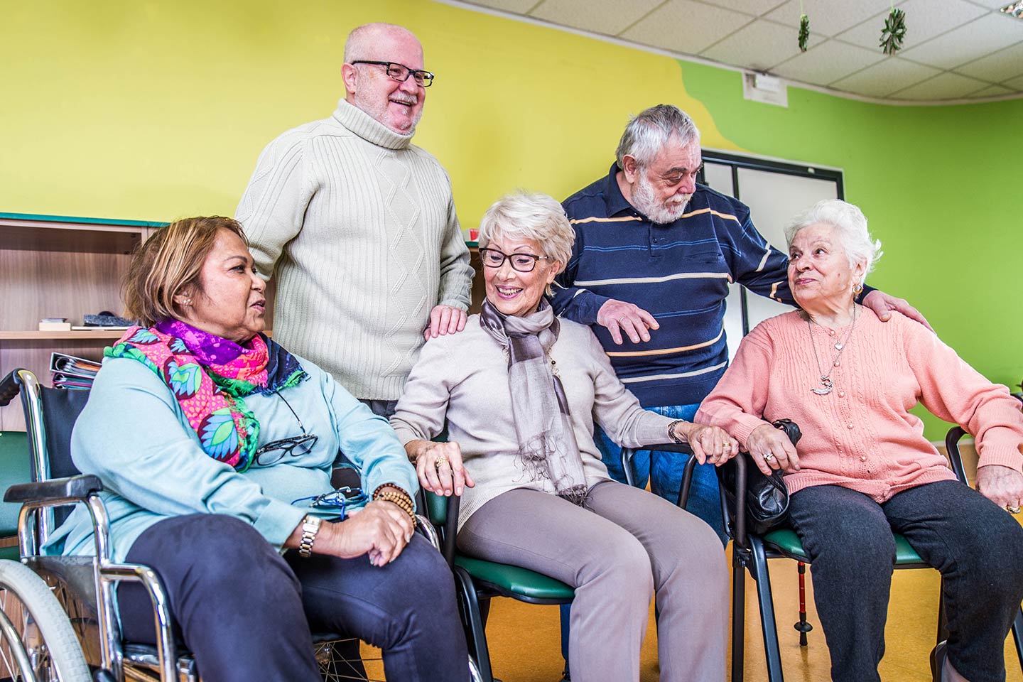 Photo of a group of five happy people seated and standing