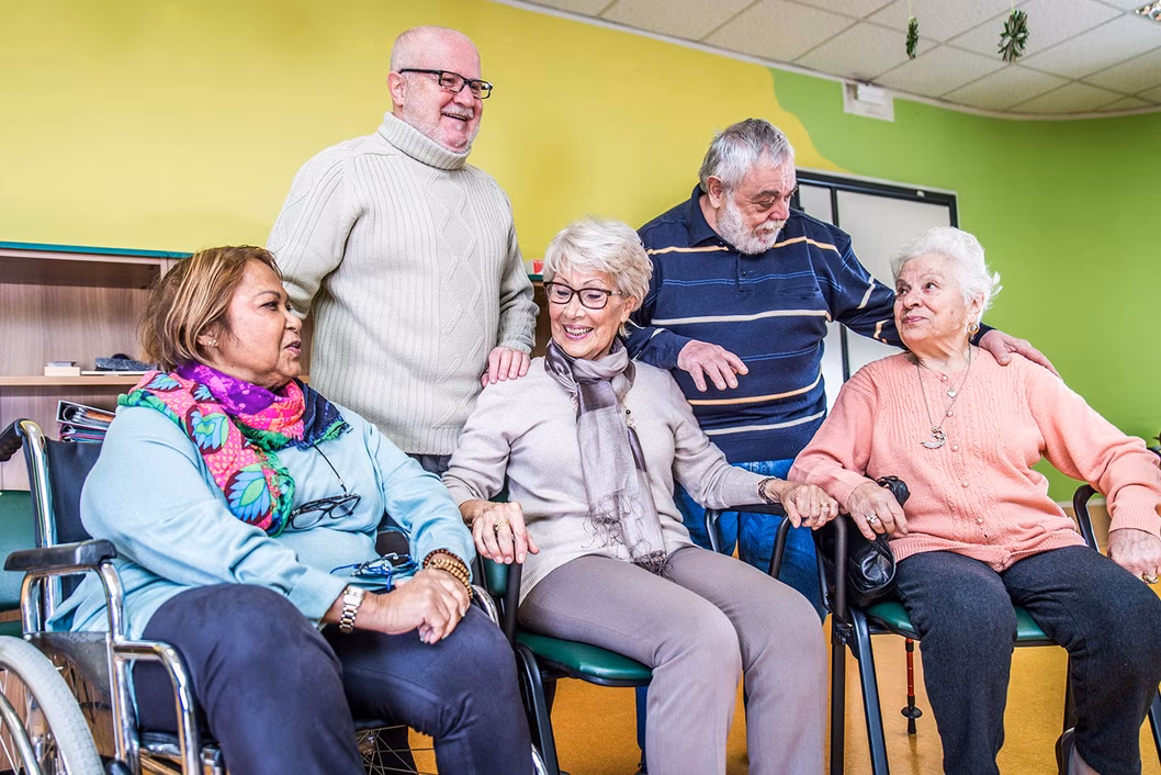 Photo of a group of five happy people seated and standing
