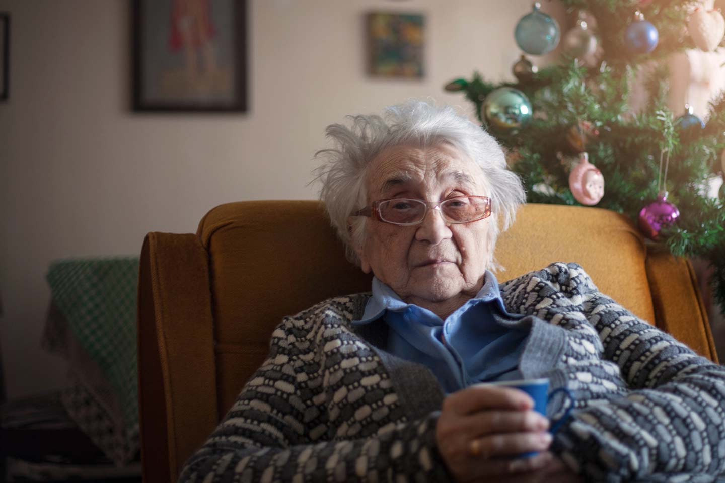 Photo of woman sitting in front of a christmas tree
