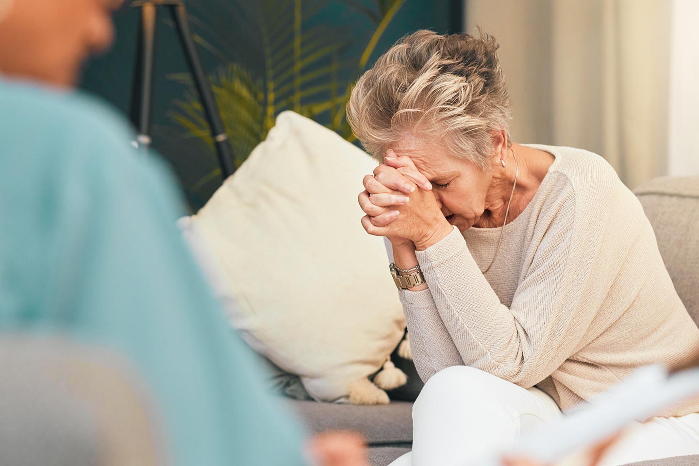 Photo of a woman in distress resting her head on her hands
