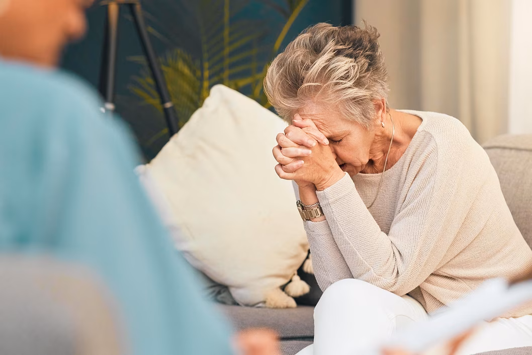 Photo of a woman in distress resting her head on her hands