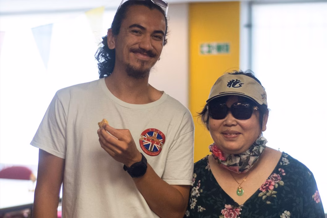 Photo of young man and older woman wearing sunglasses