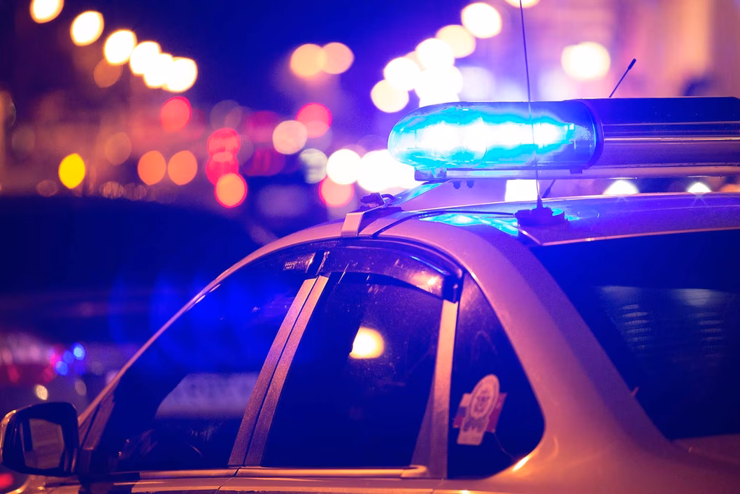 Photo of a police car with blue lights flashing at night