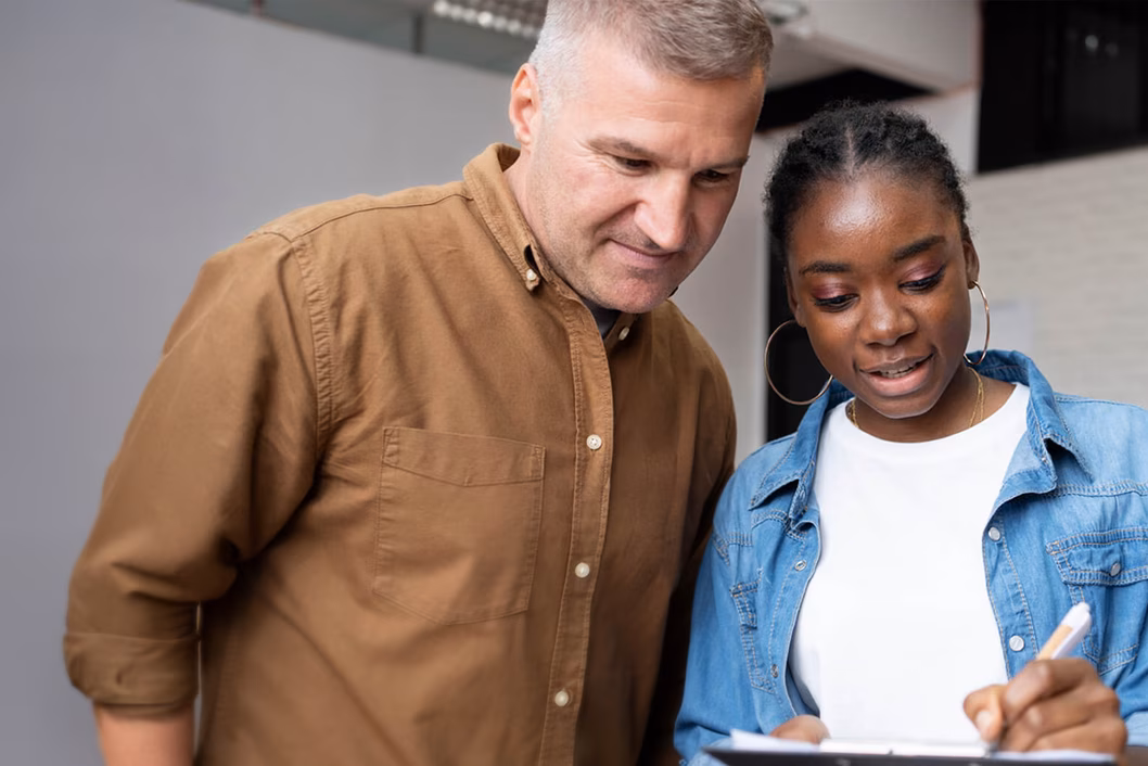 Photo of a man and a woman looking forms on a clipboard