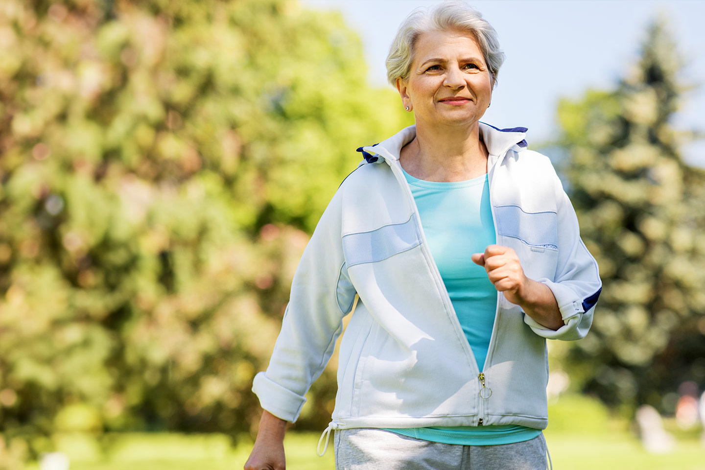 Photo of a woman on a sunny day walking in a park