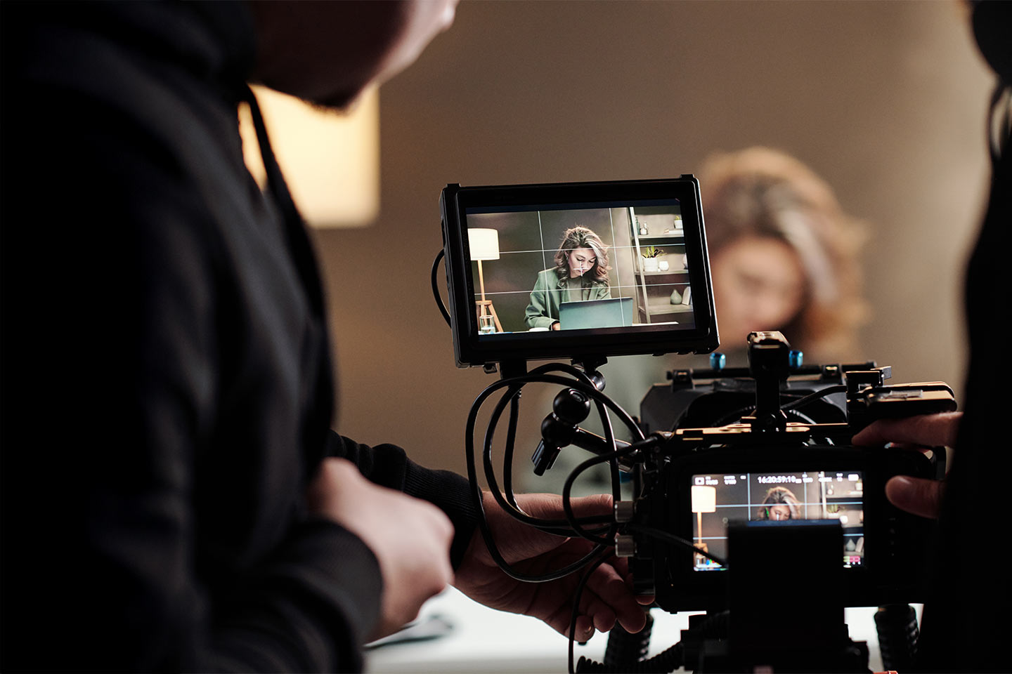 Photo of a the monitor attached to a video camera with a woman in the frame