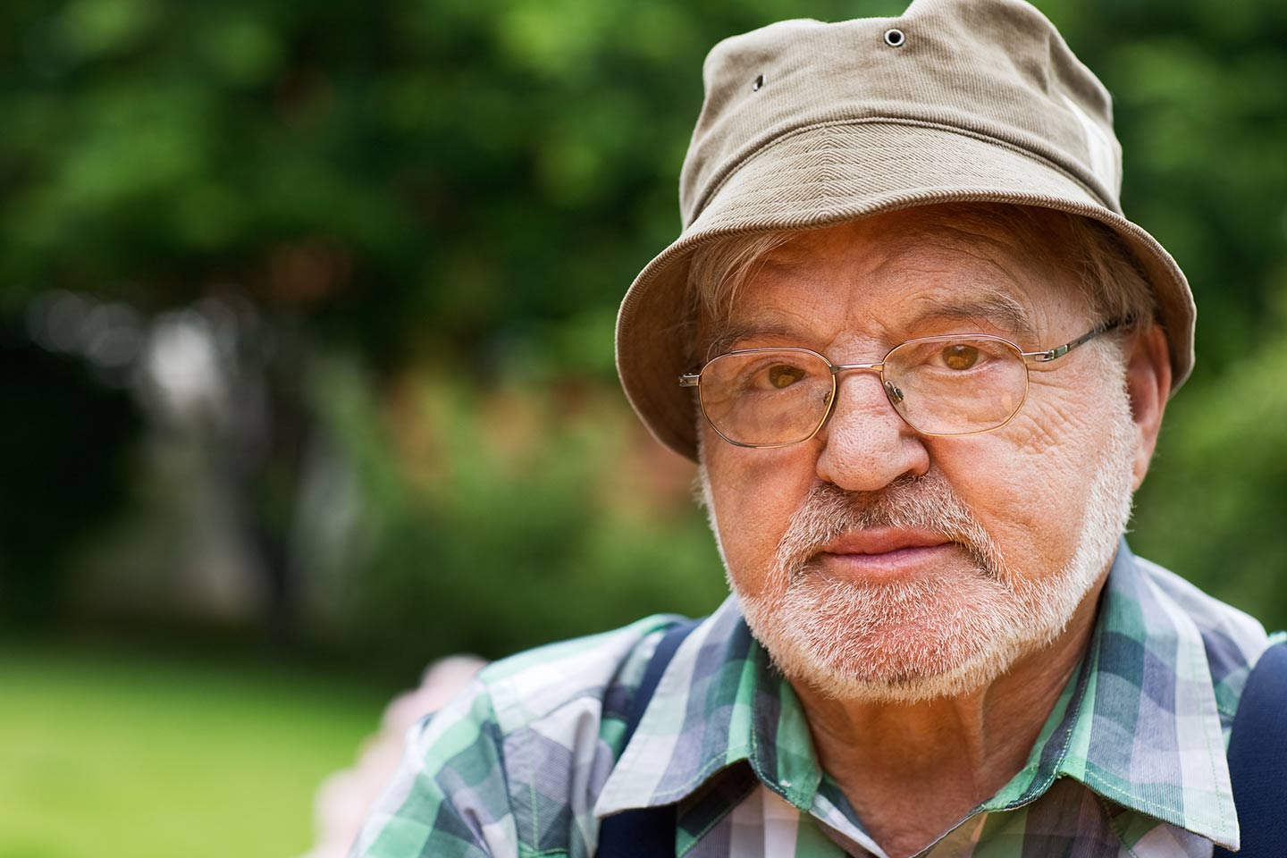 Photo of outdoorsy man wearing bucket hat and wire rimmed glasses