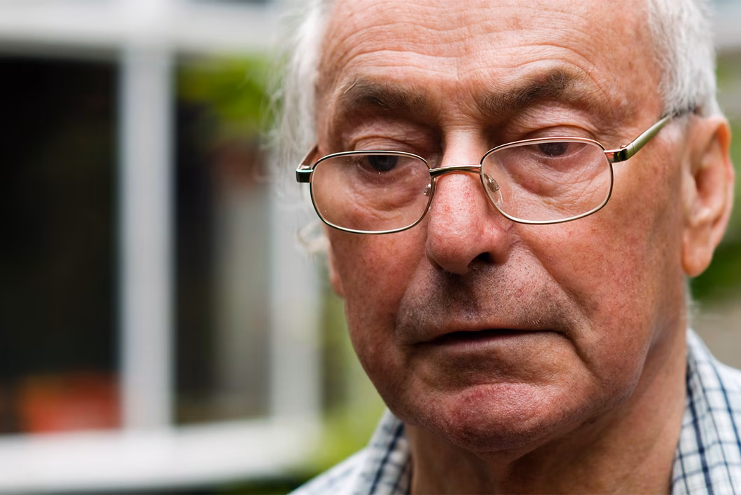 Photo of a man in a check shirt wearing spectacles