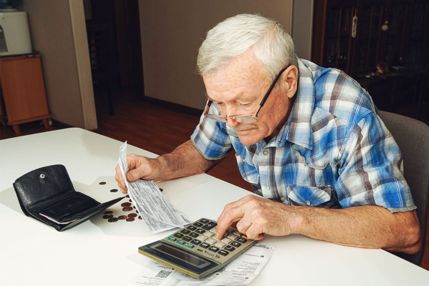 Photo of a man adding up bills with a calculator