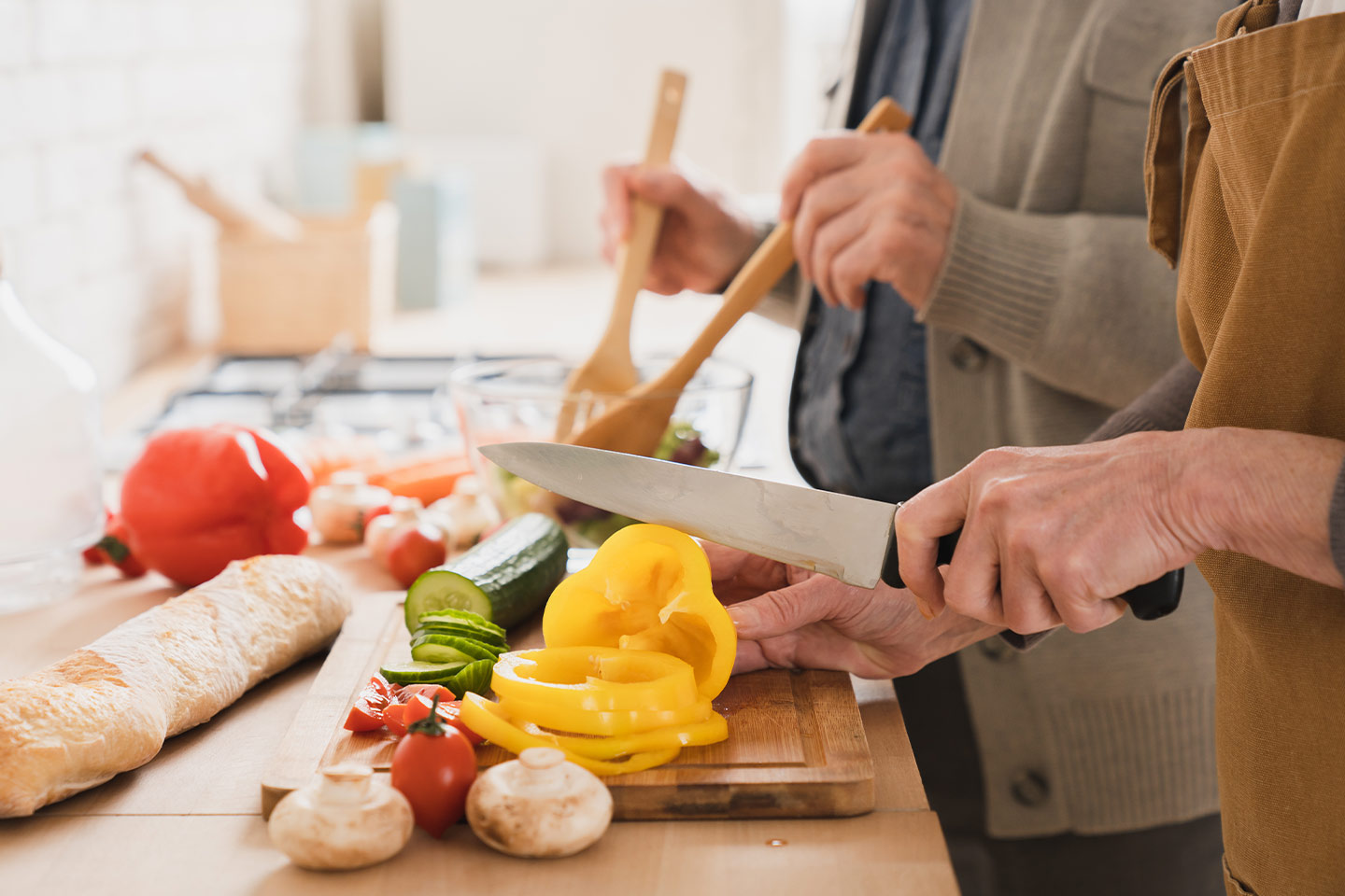 Photo of two people in a kitchen preparing vegetables
