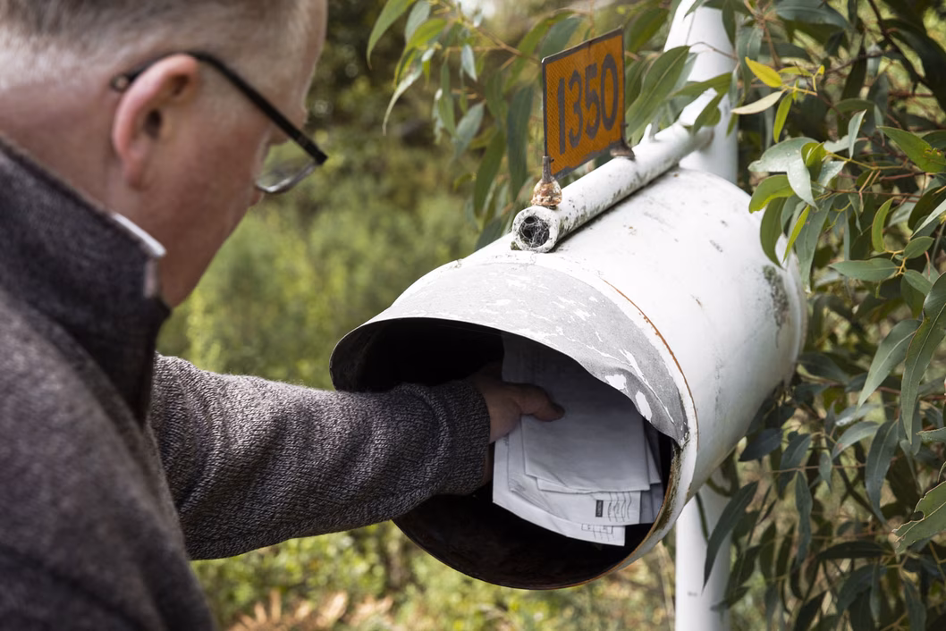 Senior man collecting mail from mailbox