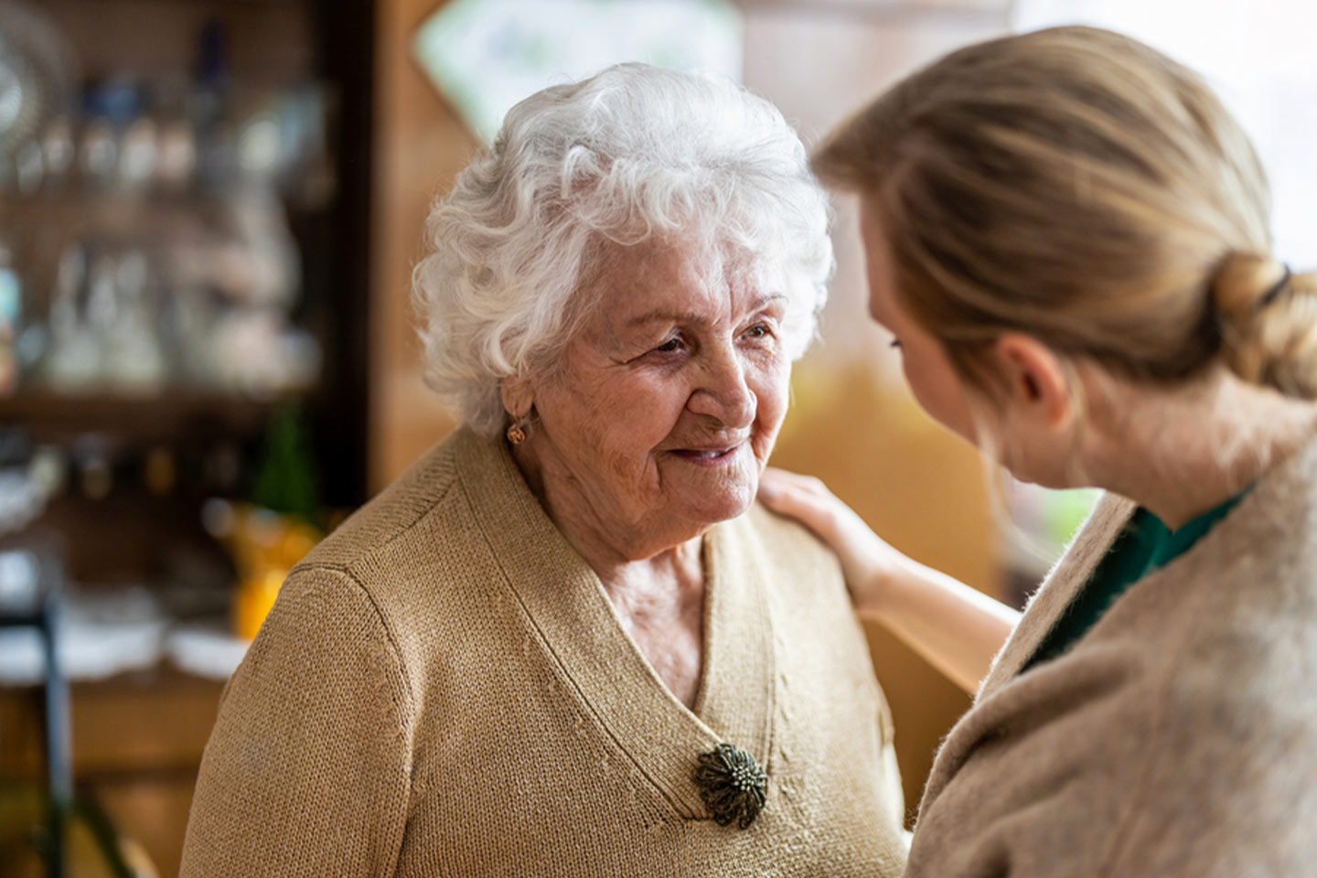 Photo of two women greeting each other in a cosy room