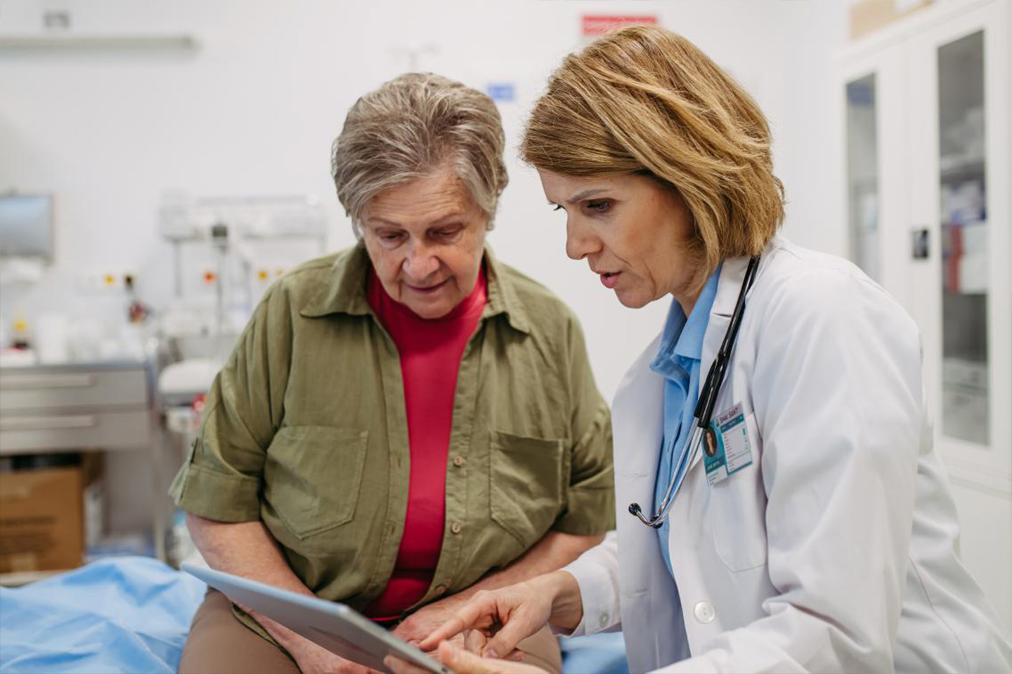 Photo of a doctor an patient looking at a computer tablet together