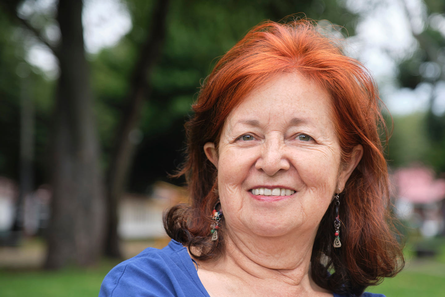 Photo of a woman with red hair outdoors in a blue top