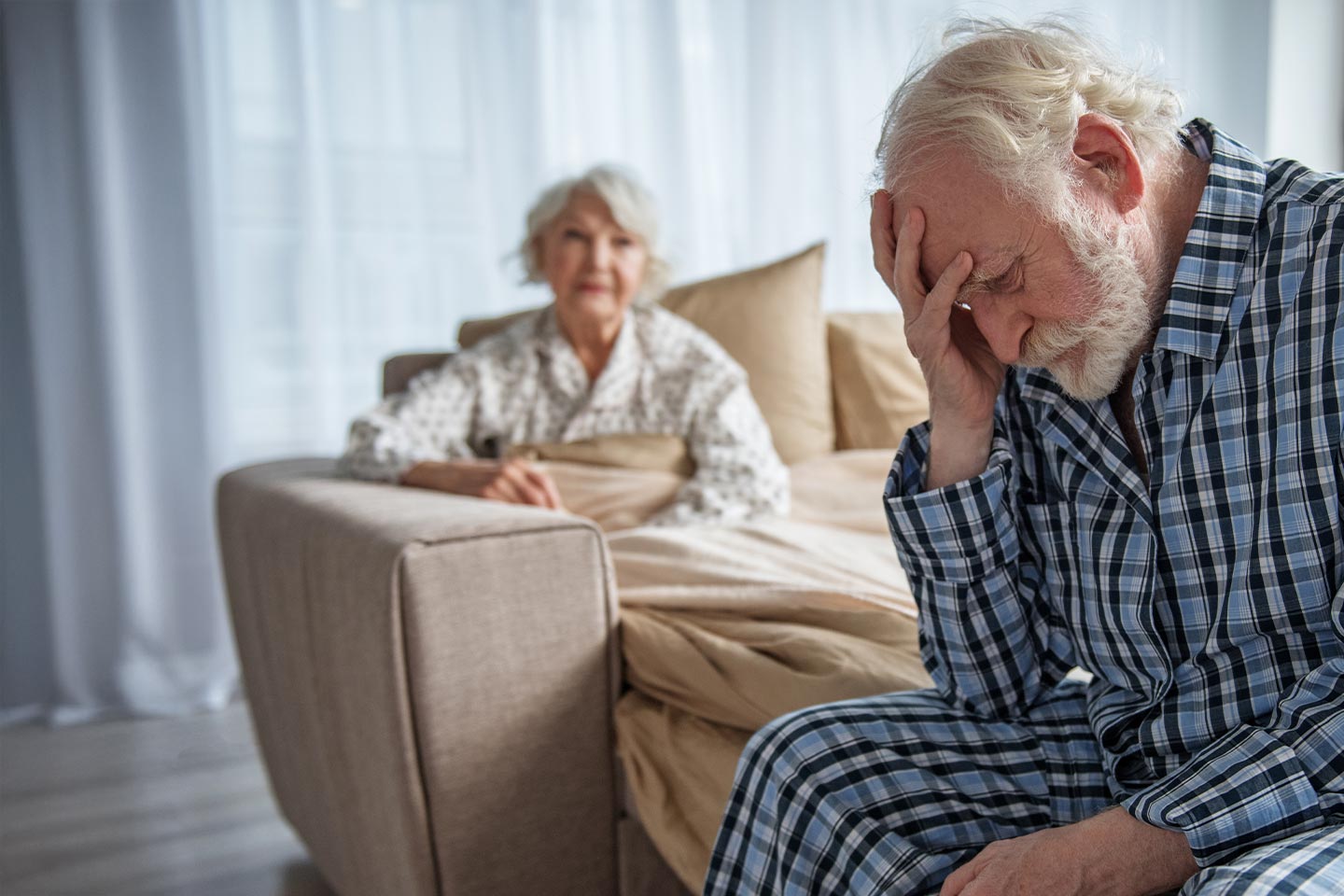 Photo of a man in pyjamas with his head in his hand