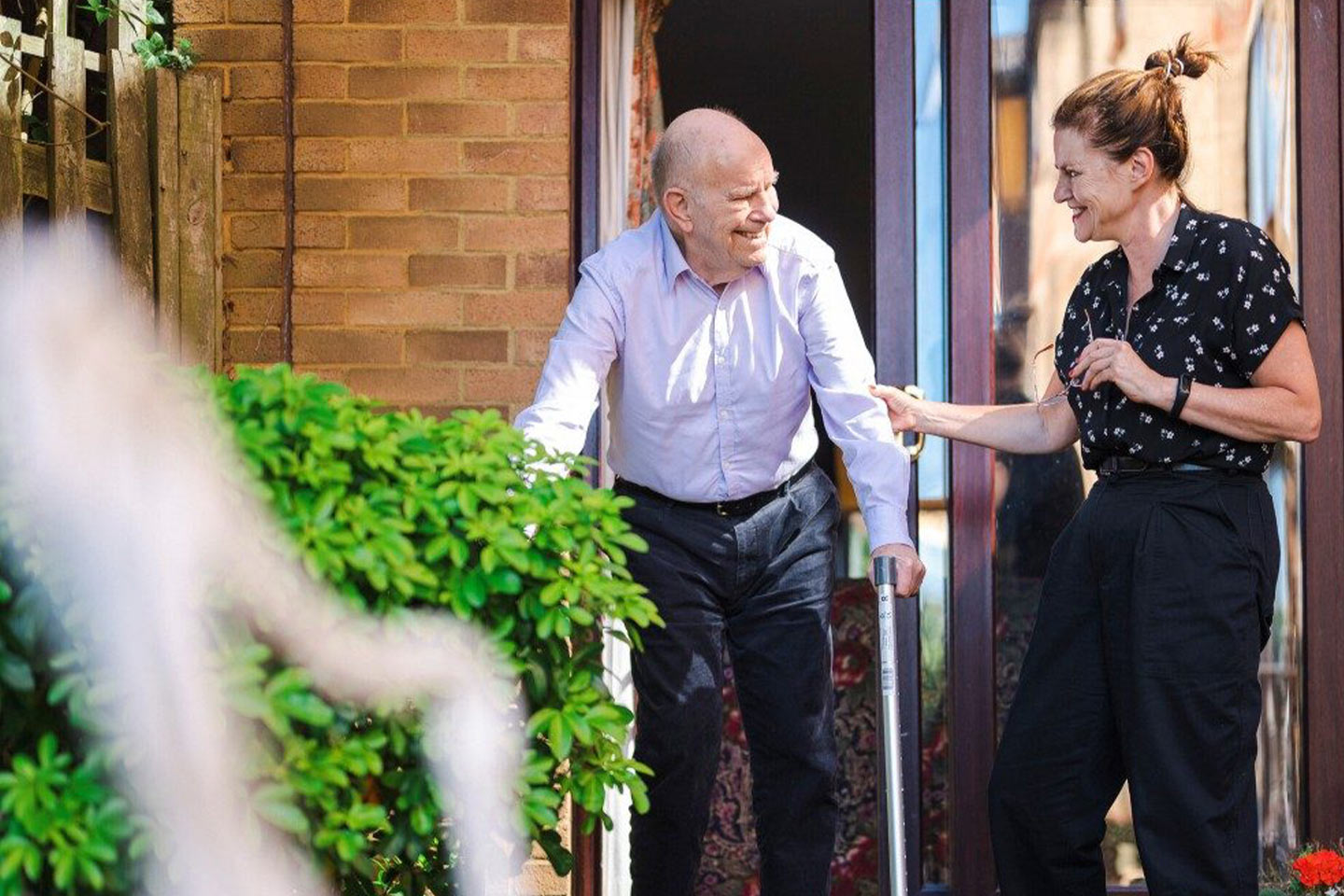 Photo of a man and woman smiling in a courtyard