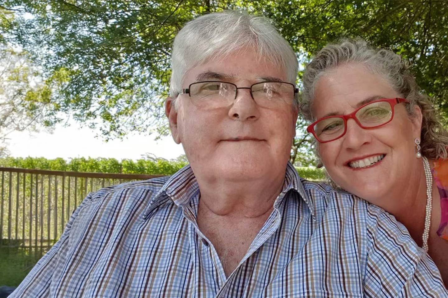 Photo of a smiling couple in a green park