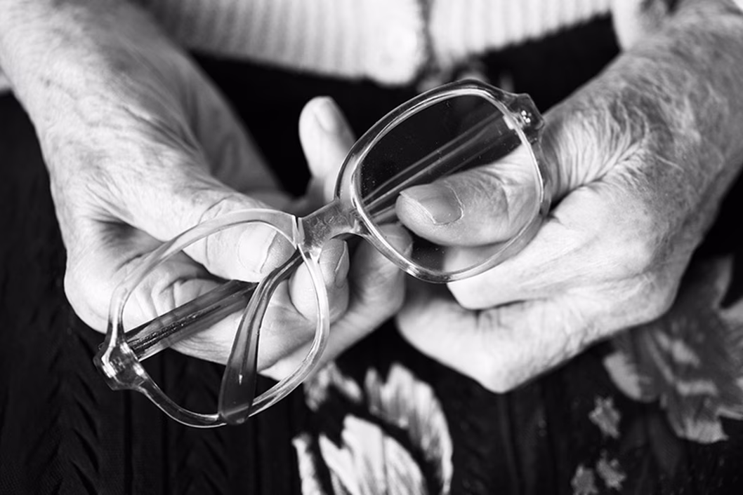 Image of an older person's hands holding some spectacles