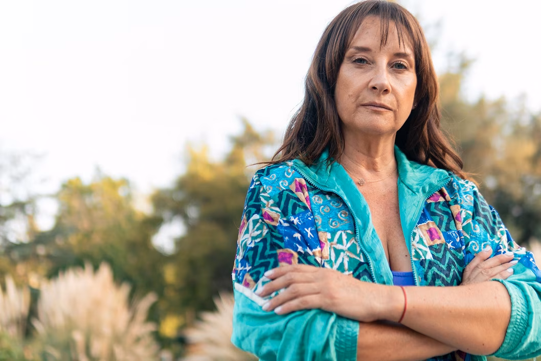 Photo of woman with crossed arms in turquoise jacket