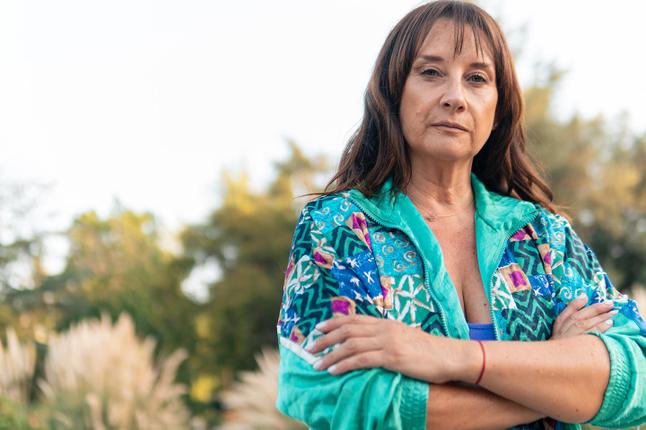 Photo of woman with crossed arms in turquoise jacket