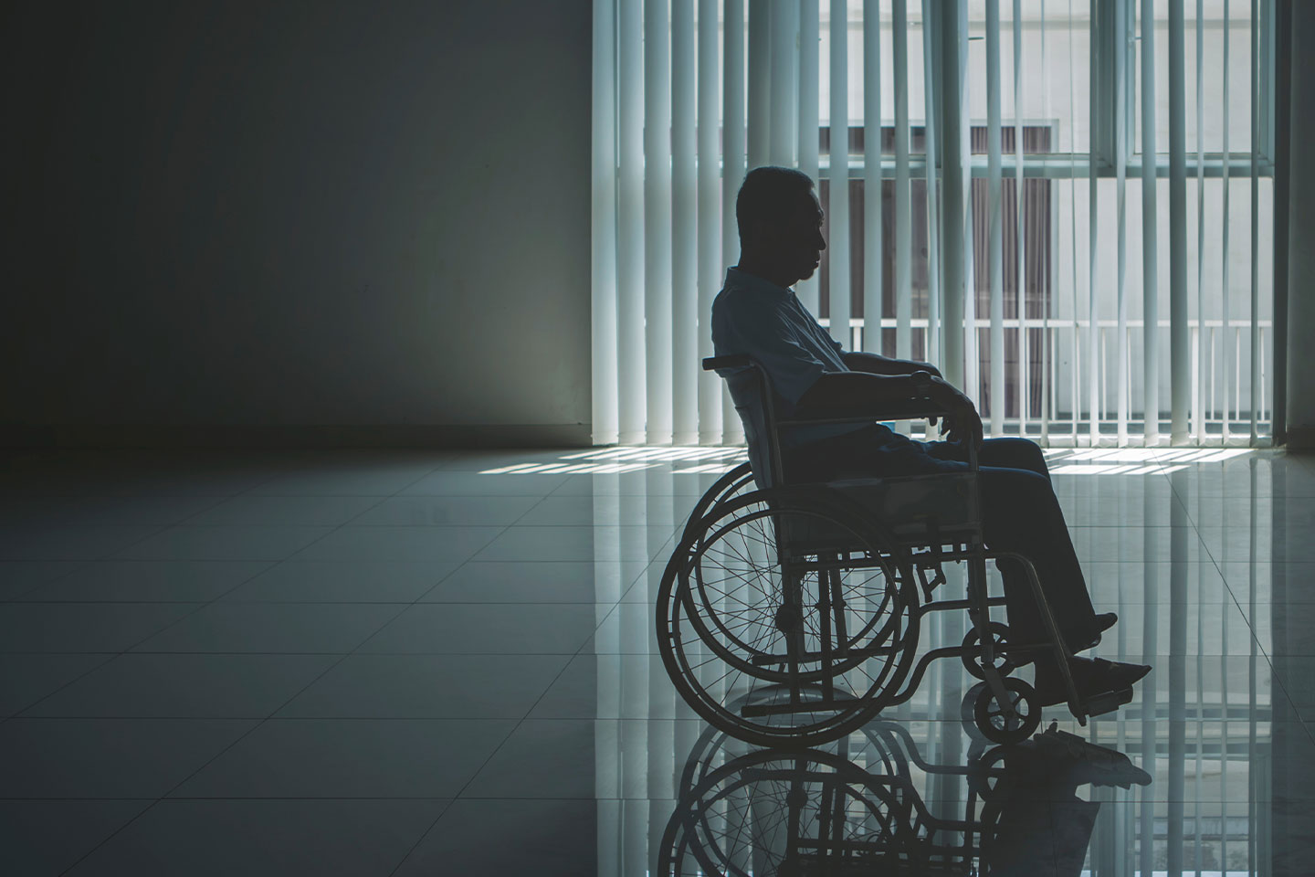 Photo of a man in a wheelchair in a darkened room