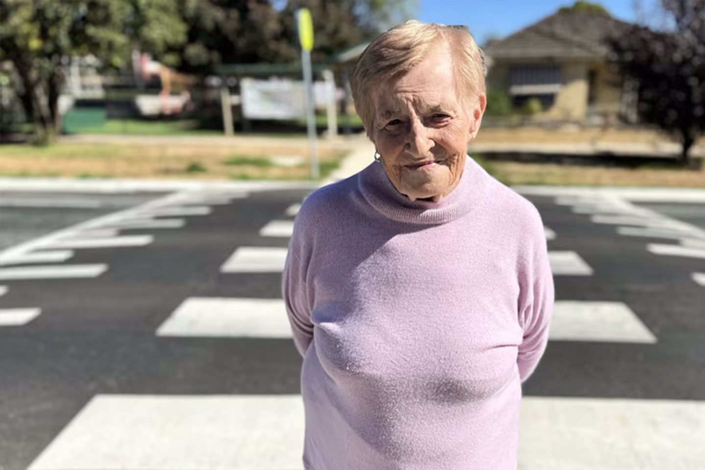 Photo of a woman in a pink jumper at a zebra crossing
