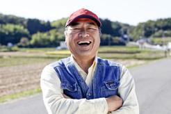 Image of a smiling Asian man wearing a red cap.